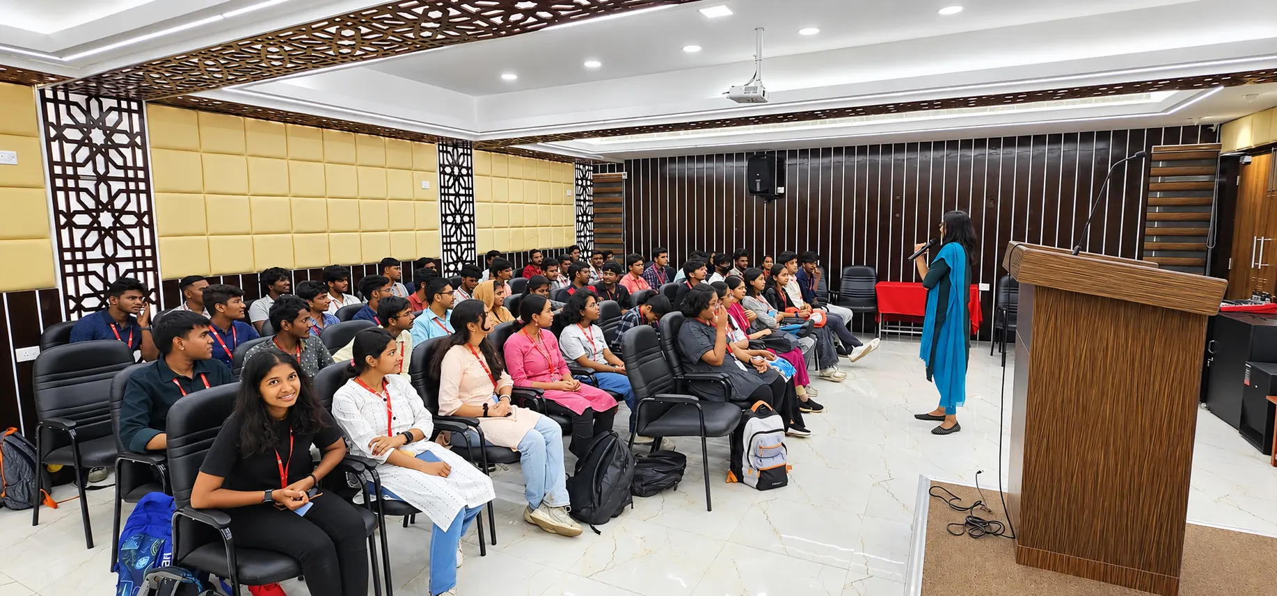 Students seated in an auditorium listening to a speaker